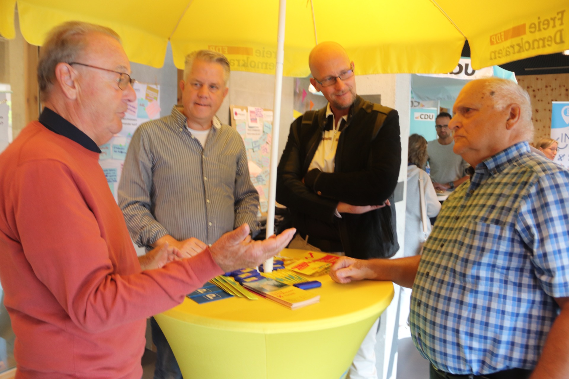 Am Stand der FDP beantworten (v.l.) Peter Meier, Tobias Jaehn und Dominik Baumeister die Fragen von Axel Zumblick. Foto: Kd