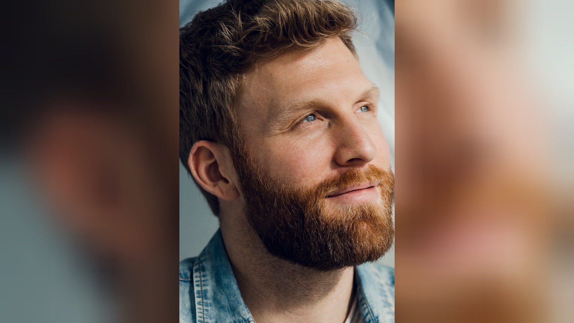 Mann mit rotem Bart und blauen Augen blickt lächelnd nach oben