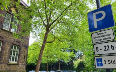 Blaues Parkschild mit drei Zusatzschildern: Parken von 8 bis 22 Uhr für maximal 3 Stunden, vor einem alten Steinhaus