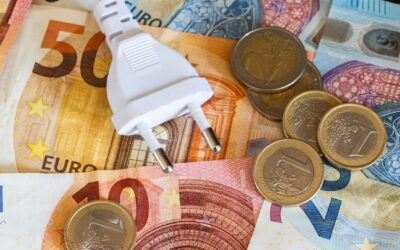 Weißer Stromstecker auf gemischten Euro-Scheinen und -Münzen