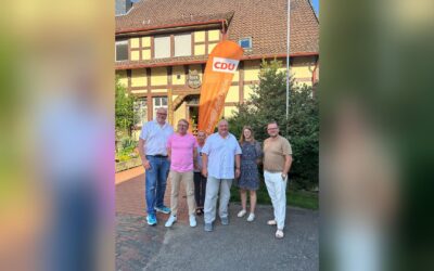 Fünf Männer und eine Frau stehen vor einem orangefarbenen CDU-Banner und Haus Berghof