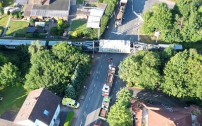 Luftaufnahme: Ein großer Trafo auf einem Tieflader kreuzt eine Wohnstraße in Leopoldshöhe, umgeben von Häusern und