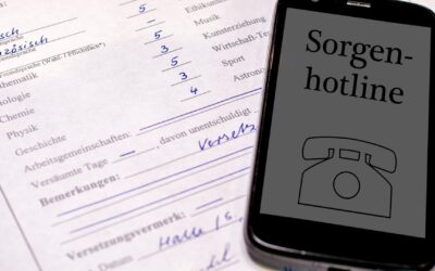 Ein Smartphone mit der Aufschrift „Sorgenhotline“ und einem Telefonsymbol liegt auf einem Schulzeugnis mit Noten