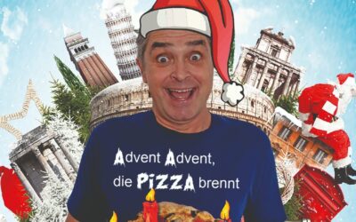 Roberto Capitoni lachend mit Weihnachtsmütze und T-Shirt "Advent Advent, die Pizza brennt", umgeben von italienischen