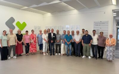 Gruppe von Männern und Frauen im Flur des Klinikums Lippe vor Wand mit Logo und Notaufnahme-Schildern