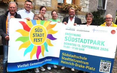 Sieben lächelnde Personen halten ein großes weißes Banner mit der Aufschrift „Südstadt Fest“ und „Eröffnung