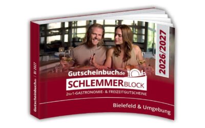 Schlemmerblock-Gutscheinbuch für Bielefeld mit lächelndem Paar, das in einem Restaurant isst und Wein trinkt