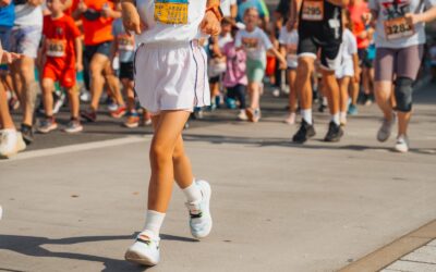 Eine Gruppe von Kindern und Erwachsenen rennt bei einem Laufwettbewerb auf einer Straße