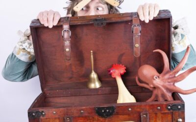 Pirat Backen-Bart-Bernd mit Löffelhut lugt hinter einer Schatztruhe mit Glocke, Huhn und Oktopus hervor