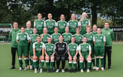 Die Ubbser Damenmannschaft in grünen Trikots mit zwei Trainern steht auf einem Fußballplatz