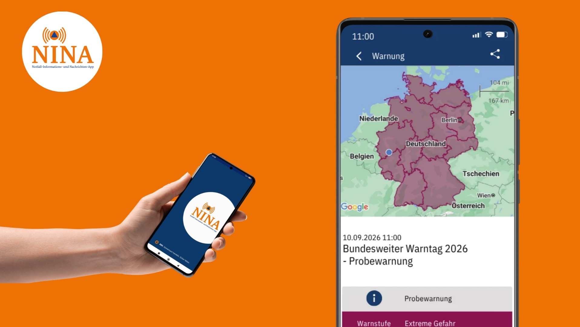Hand hält Smartphone mit NINA App, daneben großer Bildschirm mit Probewarnung zum Bundesweiten Warntag 2026 auf