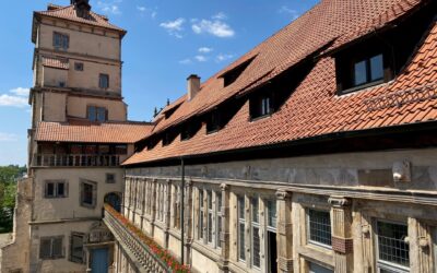 Weserrenaissance-Museum mit hohem Turm, roten Ziegeldächern, vielen Fenstern und Balustrade mit Blumen