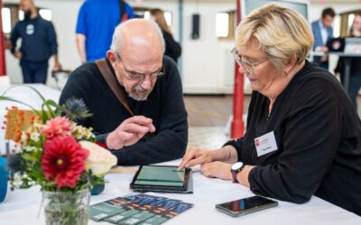 Peggy Gajewi vom Stadt Bielefeld Serviceportal und ein Mann bedienen ein Tablet